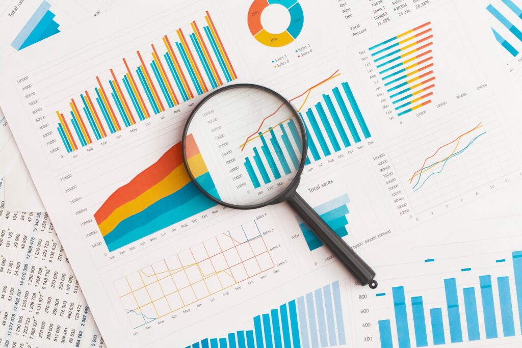 Image showing charts and data on a sheet with a magnifying glass over the top. Image(s) used under license from Shutterstock.com