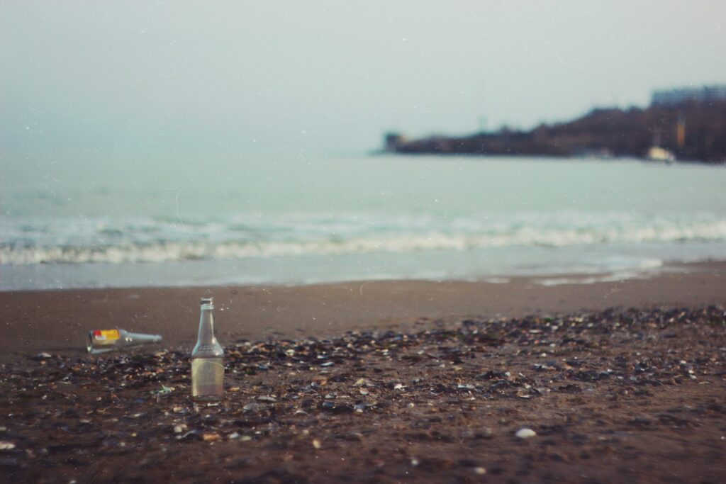 Photo of bottles on a beach by Vova Drozdey on Unsplash